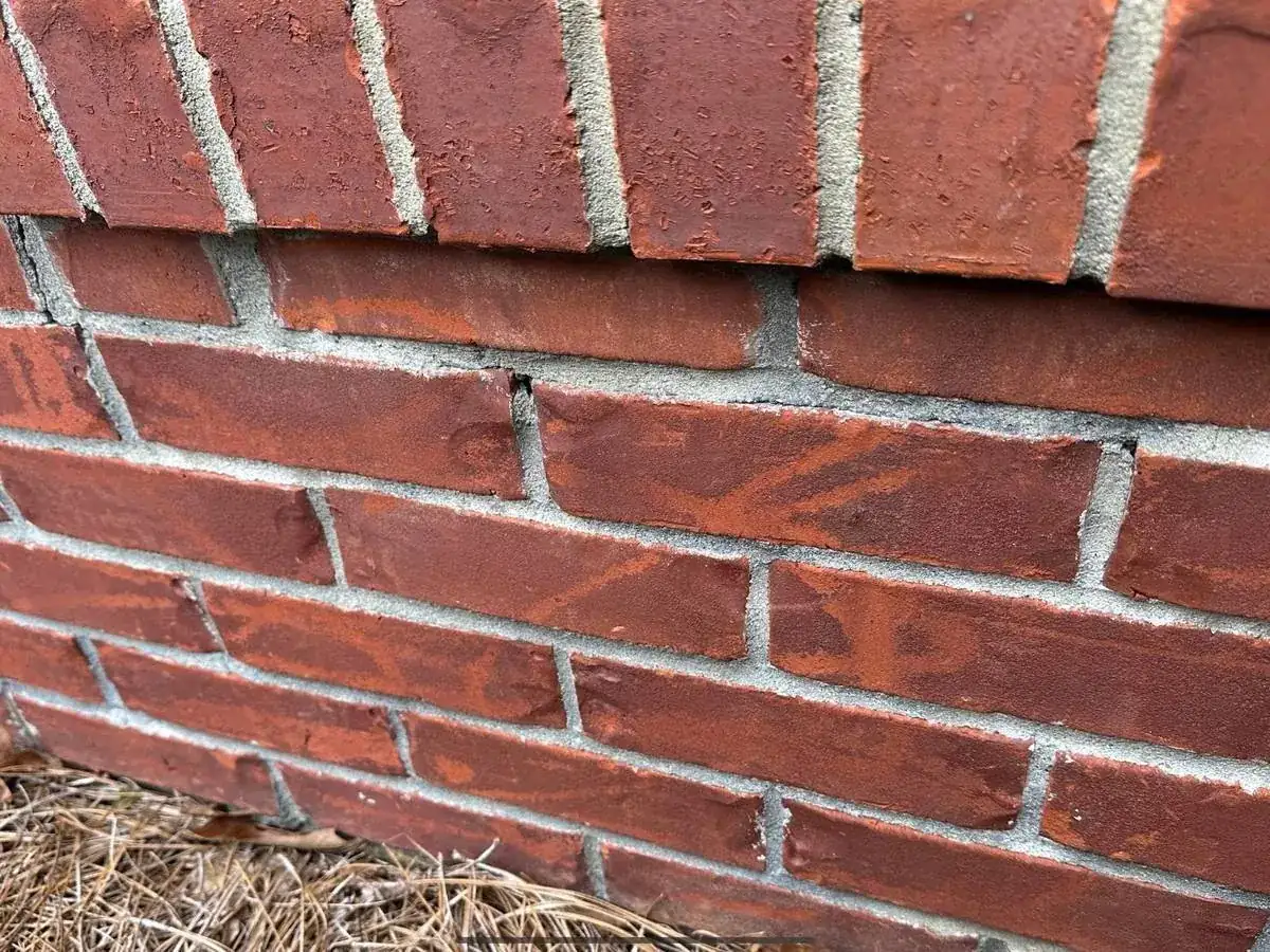 Red brick with the face and mortar joints cut by a zero-degree pressure washer tip