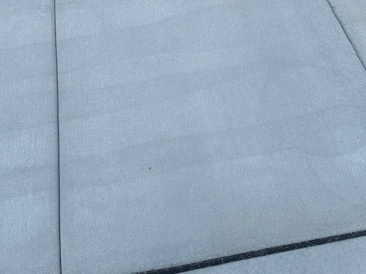 Concrete slab showing faint striping left by a pressure washer wand