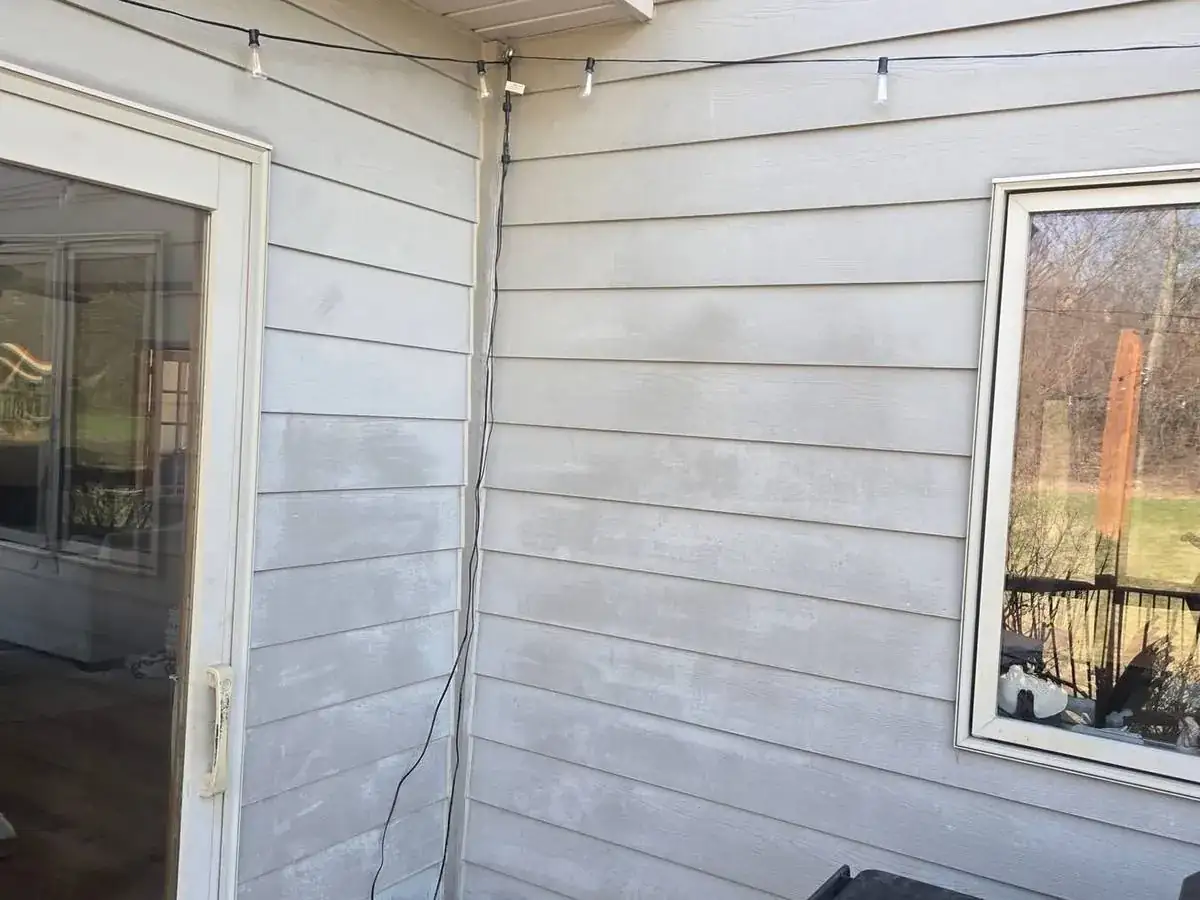 Painted lap siding with paint stripped off in pale patches