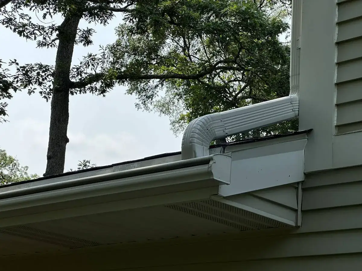 The same downspout elbow and gutter, clean after a low pressure soft wash