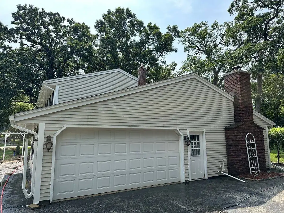 Garage side of a Delafield home before washing, growth along the siding and trim