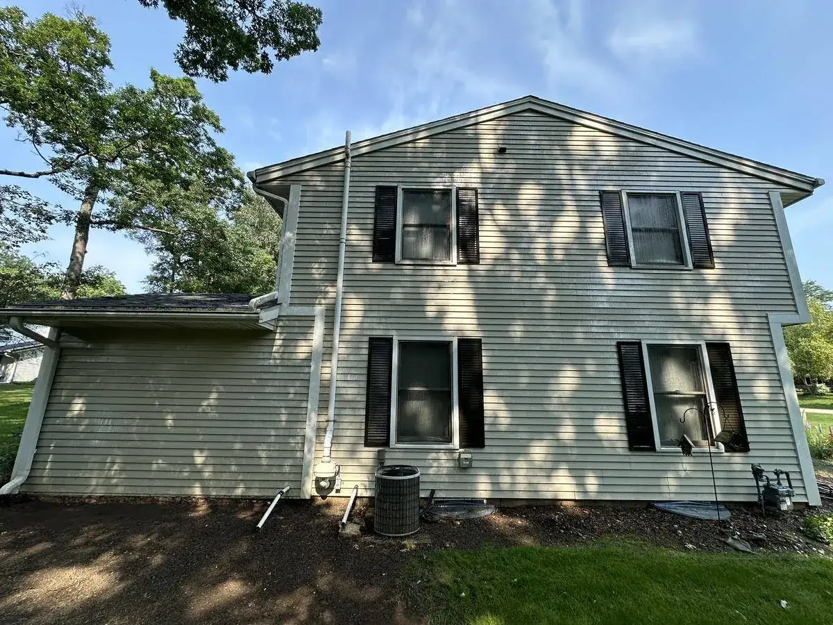 Rear elevation of a Delafield home showing years of organic growth on the siding
