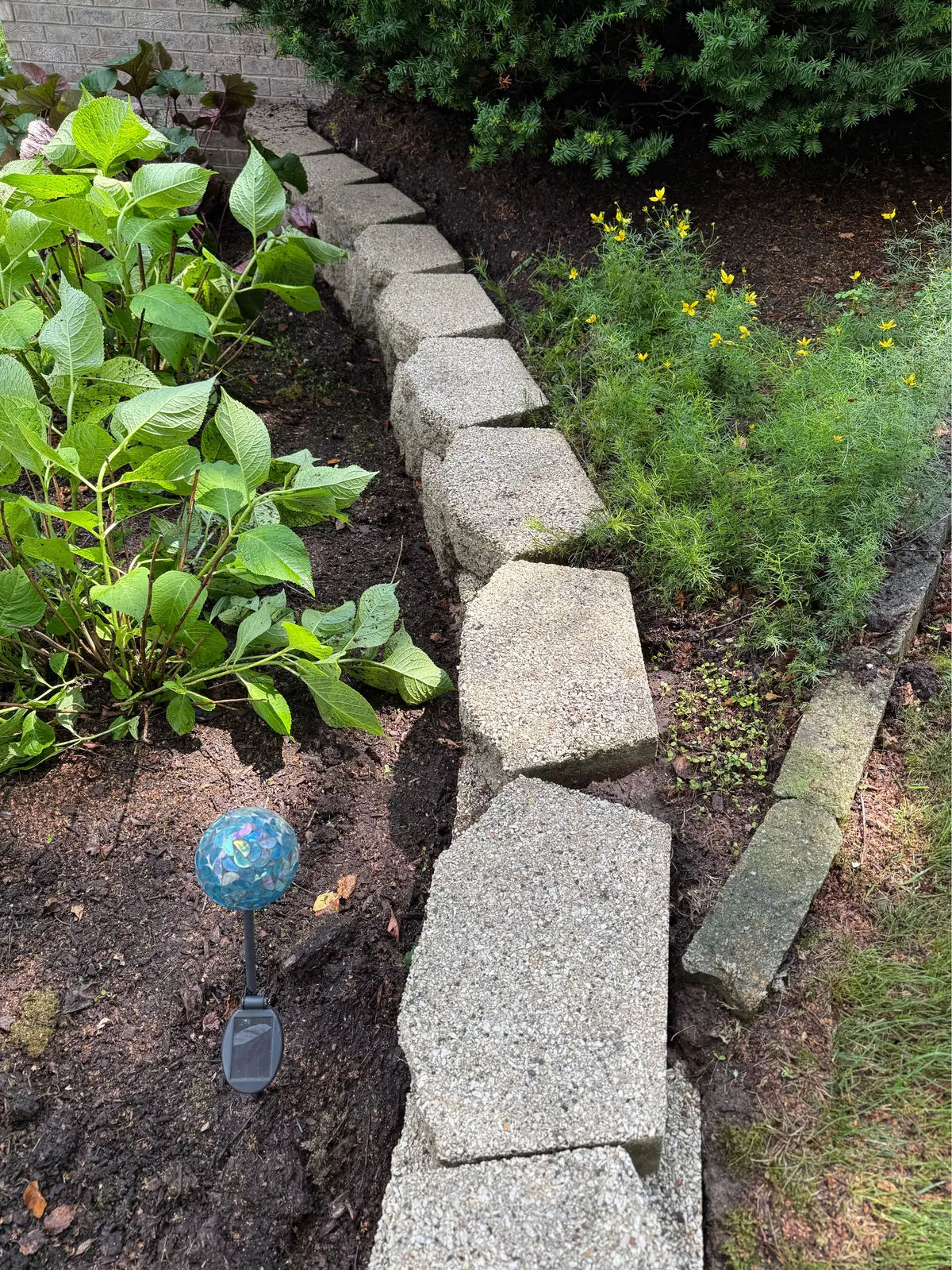 The block edging after cleaning, stone and aggregate visible again where moss had covered it